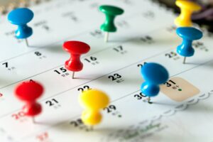Thumb tack pins on calendar as reminder
